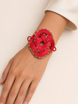 Bracciale con nodo rosso e dettagli perlati — immagine indossata o ambientata